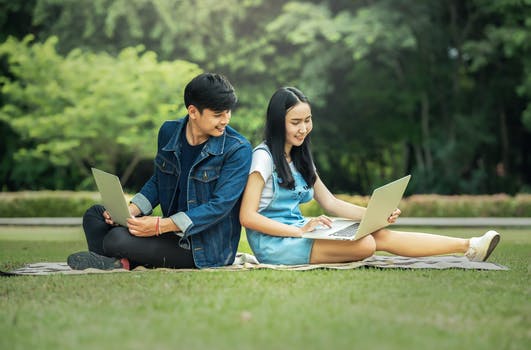 man and woman outside with computers